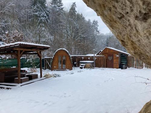 a yard covered in snow with a cabin at Wellness Kokořín in Kokořín