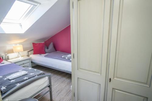 a small bedroom with a bed and a window at Frau Holle in Westerland (Sylt)