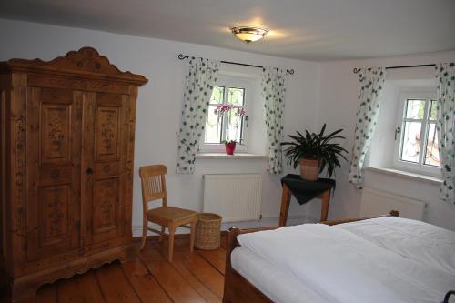 a bedroom with a bed and a cabinet and a chair at Urlaub am Bio-Bauernhof Liebchen in Zeutschach