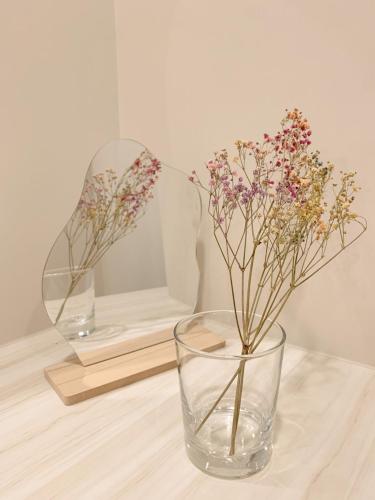 two glass vases with flowers in them on a table at 如沐咖啡旅宿 in Xingjian