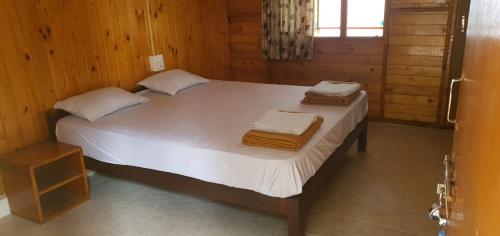 a bedroom with a large white bed with towels on it at ORANGE SKY INN HOLIDAY HOME in Canacona