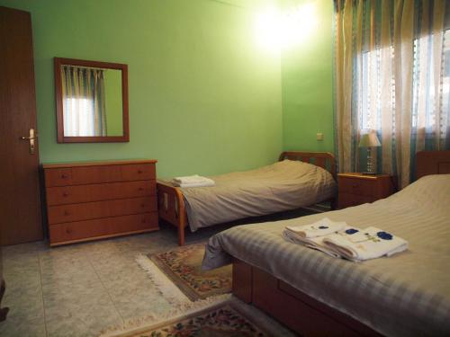 a small bedroom with two beds and a mirror at Adam's House in Tríkala