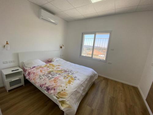 une chambre blanche avec un lit et une fenêtre dans l'établissement צימר סוד החרמון, à Majdal Shams