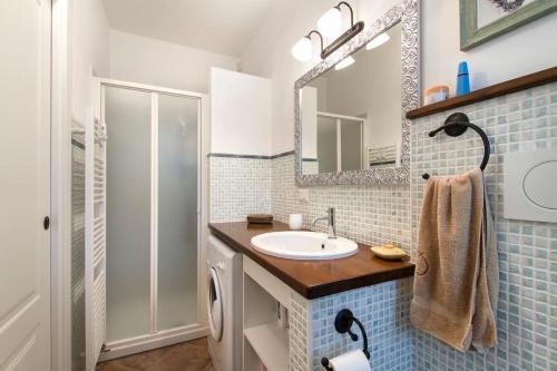 bagno con lavandino e specchio di Appartamento Caretto a Baveno