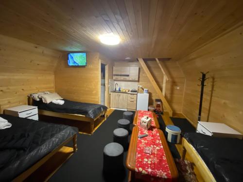 a room with two beds and a table in a cabin at UVAC-Etno selo Kaćo in Sjenica