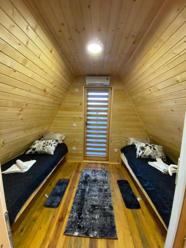 a room with two beds in a wooden cabin at UVAC-Etno selo Kaćo in Sjenica