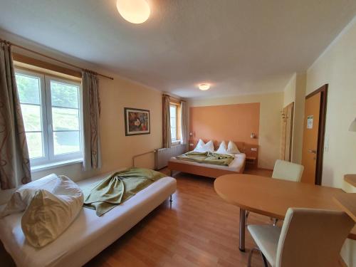 una camera d'albergo con due letti e un tavolo di Gasthof Zur Post a Ossiach
