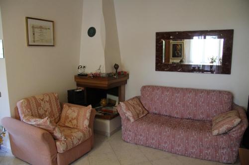 sala de estar con sofá y silla en B&B Valmarecchia, en Poggio Berni