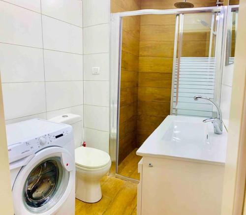 a bathroom with a washing machine and a toilet at Royal Apartments , Blvd Nitza 8 in Netanya
