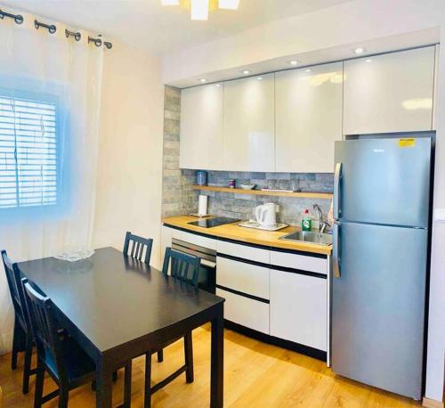 a kitchen with a dining table and a refrigerator at Royal Apartments , Blvd Nitza 8 in Netanya