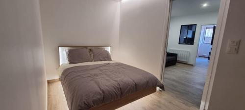 Cama en habitación blanca con espejo en Le Faubourg Dieppe, en Dieppe