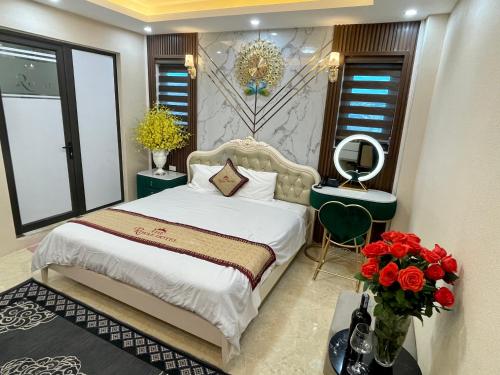 a bedroom with a bed and a vase of flowers at The Royal Hotel Near West Lake in Hanoi