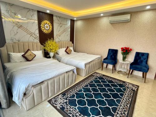 a hotel room with two beds and two chairs at The Royal Hotel Near West Lake in Hanoi