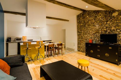 ein Wohnzimmer mit einer Steinmauer sowie einem Tisch und Stühlen in der Unterkunft Gîte Ohlavache! in Champtoceaux