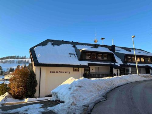 ein schneebedecktes Gebäude mit einer Straße davor in der Unterkunft Cozy Condo, Ski in and Out in Todtnau