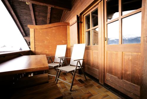 two chairs and a table in a room with a window at Alpenchalet Reit im Winkl in Reit im Winkl