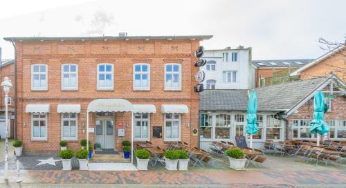 a large brick building with tables and chairs in front of it at Sterntaler in Westerland (Sylt)