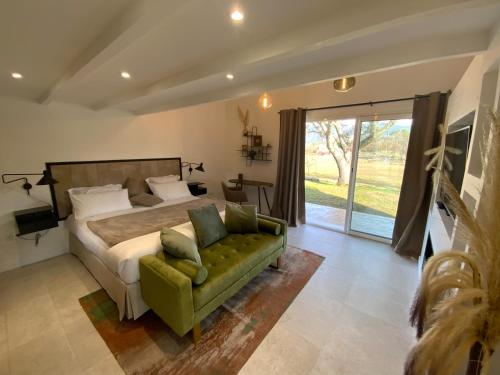 a bedroom with a bed and a green couch at Le Hameau des vanades in Ampus