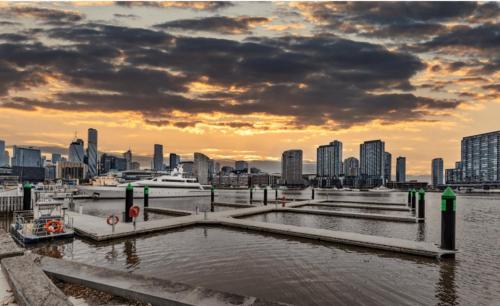 a view of a harbor with a city in the background at Lovely waterfront condo with swimming pool and gym in the heart of Docklands in Melbourne