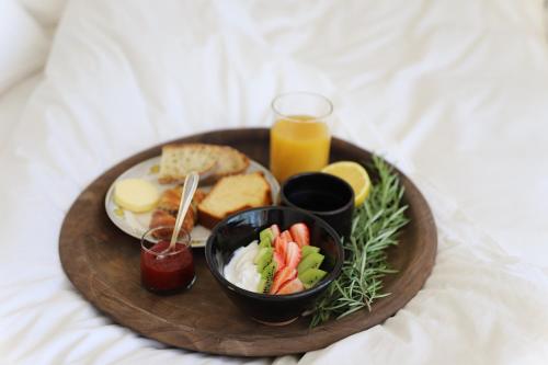 - une assiette de petit-déjeuner sur un plateau en bois avec du jus dans l'établissement Maison d’hôte Les Grands Chênes, à Valojoulx