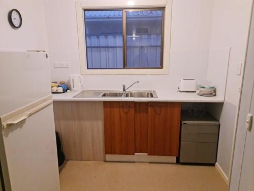 eine Küche mit einem Waschbecken und einem Fenster in der Unterkunft City Centre Apartments in Coober Pedy
