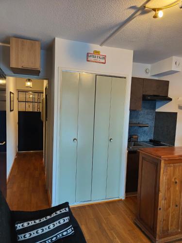 Il comprend un salon avec une armoire blanche et une cuisine. dans l'établissement Foux d Allos - Studio au cœur de la station, à La Foux