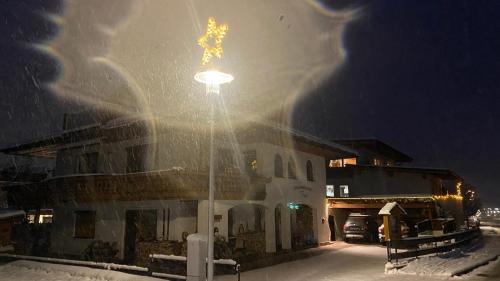 a street light in the snow in front of a building at Ferienwohnungen Flörl in Zell am Ziller