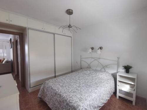 una camera bianca con letto e ventilatore a soffitto di Apartamento totalmente equipado con jardín y WiFi Santa Pola Gran Alacant a Gran Alacant