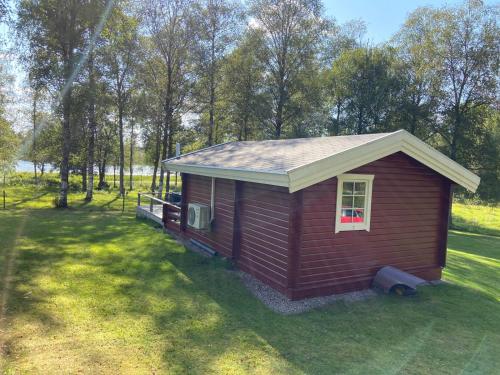 a small house in the middle of a field at Ryasjö Holiday Homes in Sexdrega