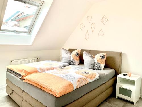 um quarto com uma cama com almofadas e uma janela em Eigenes Apartment im Herzen der Stadt mit Balkon und WLAN III em Cottbus