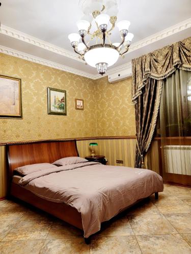 a bedroom with a bed and a chandelier at PremierAtlant in Dnipro