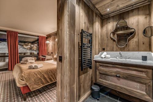 a bedroom with a bed and a tub in it at Hotel & Spa Le Val d'Isère in Val dʼIsère