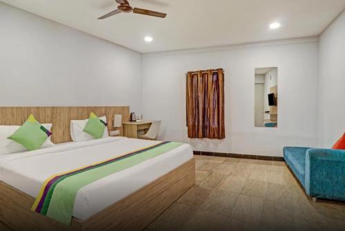 1 dormitorio con 1 cama grande y 1 silla azul en Hotel Richmond Residency, en Bangalore