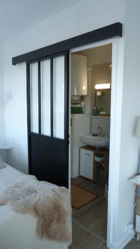 a bedroom with a door leading to a bathroom at Studio vue panoramique sur mer in Villers-sur-Mer
