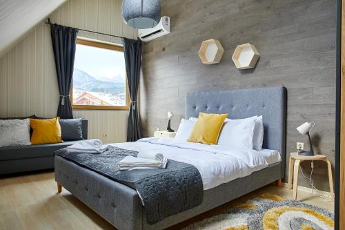 a bedroom with a large bed and a couch at BOUTIQUE Hotel ENTRY E in Bansko