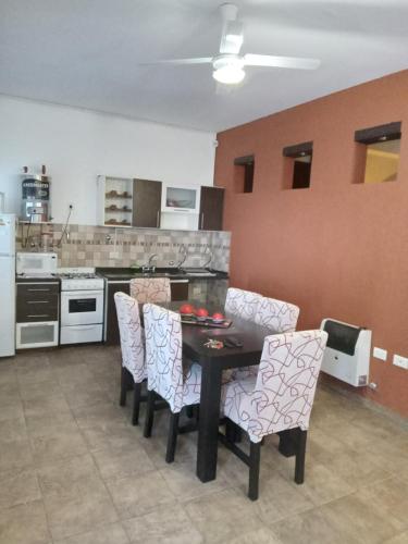 een keuken met een tafel en stoelen in een kamer bij departamento del centro in La Falda