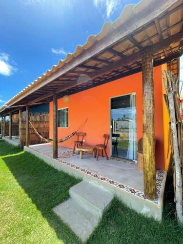 dom z pomarańczową ścianą i patio w obiekcie Sol Beach w mieście São Miguel dos Milagres