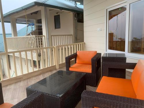 a porch with chairs and tables and an umbrella at Karinya Villas in Nainital