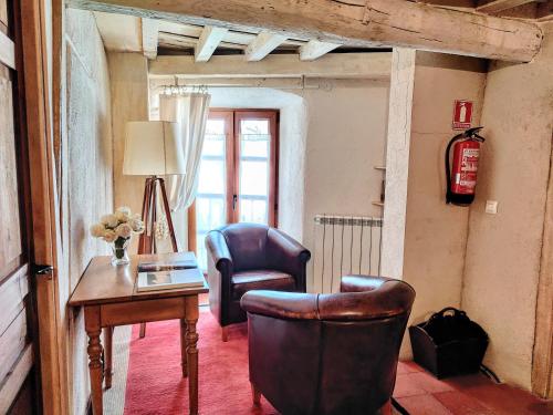 a living room with a desk and two chairs and a table at Posada Restaurante Casa de la Sal in Candelario