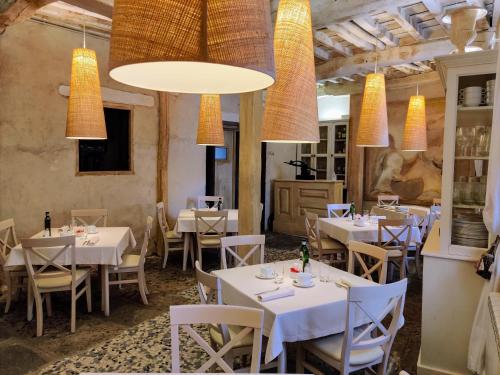 a restaurant with white tables and chairs and lights at Posada Restaurante Casa de la Sal in Candelario