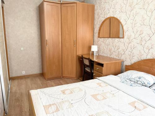 1 dormitorio con escritorio, 1 cama y una silla de escritorio en Apartment on Astana 12/1, en Öskemen