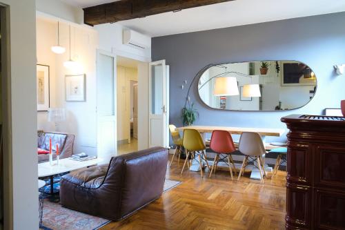 uma sala de estar com uma mesa e cadeiras e um espelho em Vicolo Folletto Home em Reggio Emilia