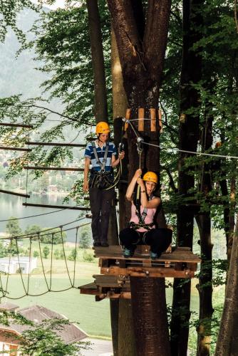 a man and woman on a zip line in a tree at Gasthof Zur Post in Ossiach