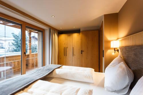 sypialnia z łóżkiem i dużym oknem w obiekcie Pension Bergheim w Reith im Alpbachtal