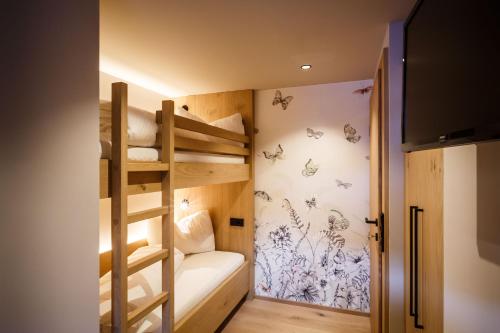 a room with two bunk beds and a staircase at Pension Bergheim in Reith im Alpbachtal