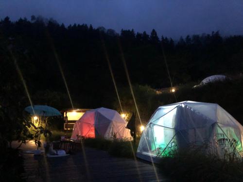 two tents in a field at night at Kubah Bali Glamping in Kintamani