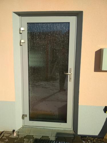 a glass door with a person standing behind it at J&K Štrba in Poprad