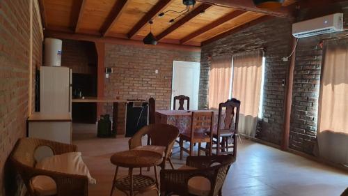 Habitación con mesa, sillas y pared de ladrillo. en Cabaña Solares en La Silleta