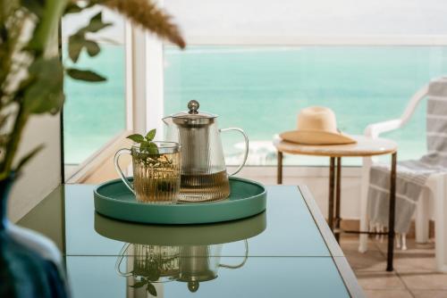 a table with a tea kettle on top of it at Vert Dead Sea by AFI Hotels in Ein Bokek
