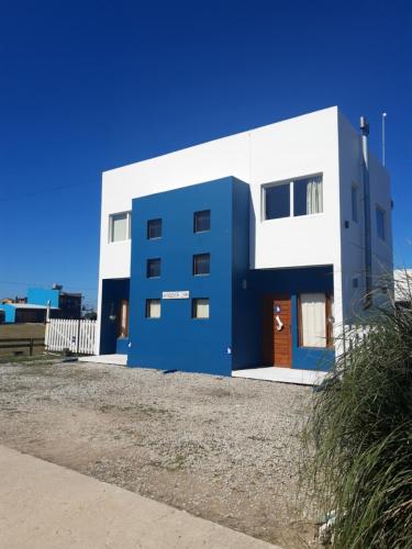 un edificio azul y blanco en la playa en Cabañas Casazul en Santa Clara del Mar